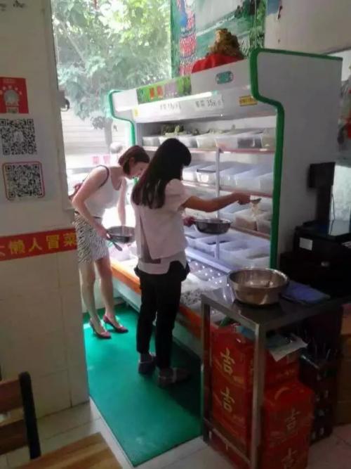 两个美女正在挑选自己爱吃的菜品